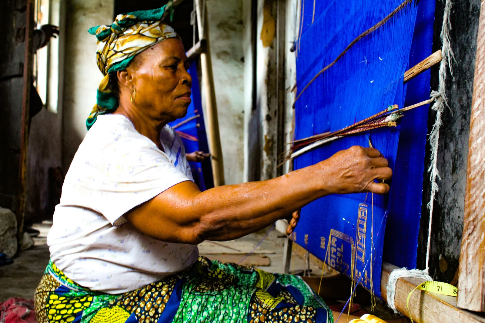 An old woman weaves at a loom in her house in Akwete, Abia State in Eastern Nigeria.